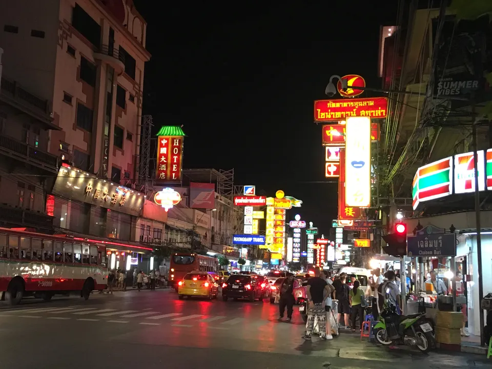 Neon signs, traffic and pedestrians on Yaowarat Road at night in Bangkok