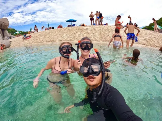 Tommy and travellers wearing snorkel masks in the water